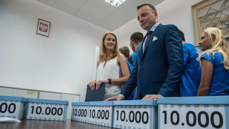 Łukasz Gibała składający podpisy pod referendum w 2016