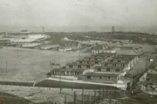 Na zdjęciu po prawej stronie placu apelowego widoczne są baraki dla polskich więźniów. (Fot. 1944 r., obiekty na planie obozowym oznaczono numerami 52-57)